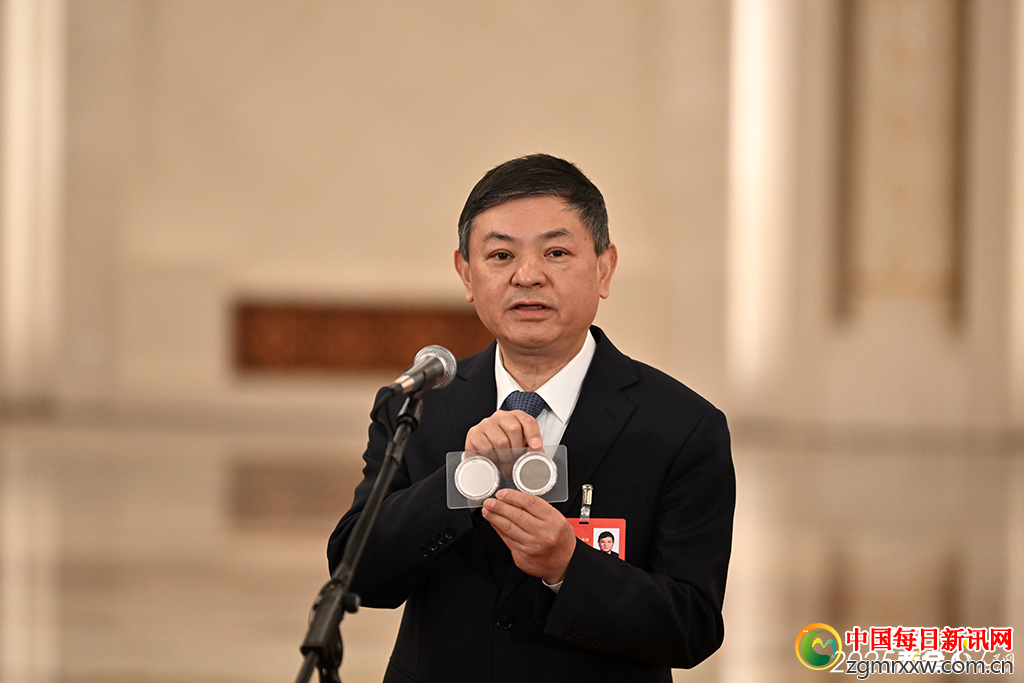 在十四届全国人大三次会议第二场“部长通道”上，生态环境部部长黄润秋展示了北京大气环境监测仪上的两块滤膜。人民网记者 翁奇羽摄