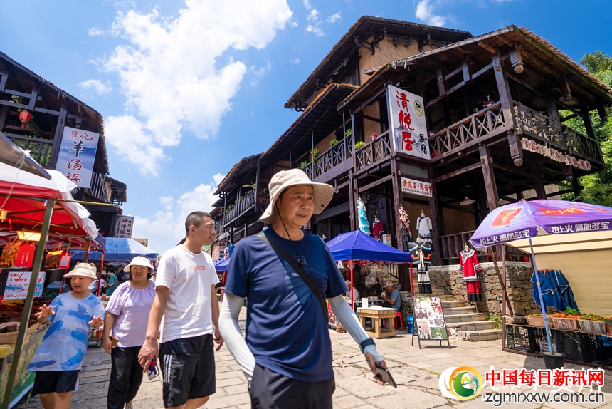 游客在景区内的海坪彝族特色旅游度假小镇参观游览。人民网记者 涂敏摄